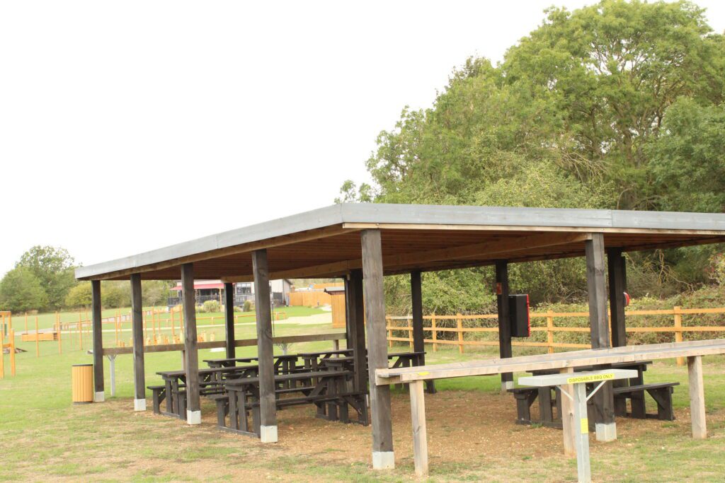 The open-sided timber BBQ and picnic shelter on the green at Rockingham Forest Park